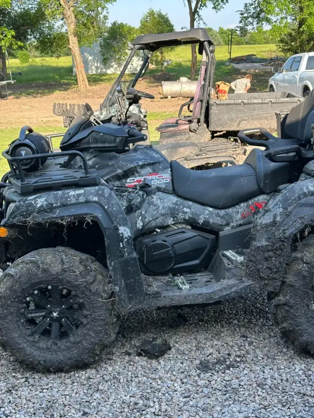 Close-up of a mud-splattered camo CFMOTO CFORCE 1000 ATV.